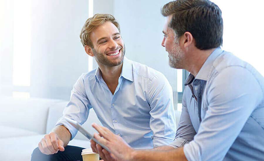 Two professionals talking over a meeting table.